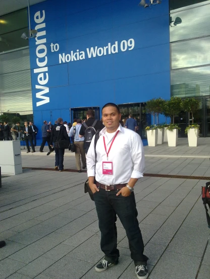 a man standing outside a building in front of the nokia world
