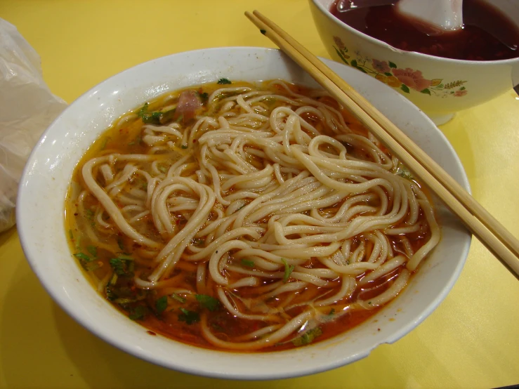 a large bowl of noodles on a yellow tray