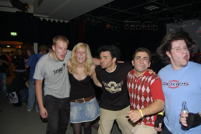 a group of young people standing next to each other in front of a crowd