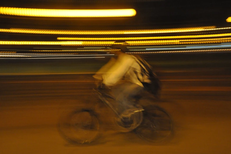 a man riding a bicycle down a street at night