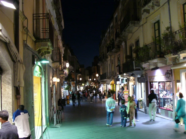 a city street at night filled with lots of people