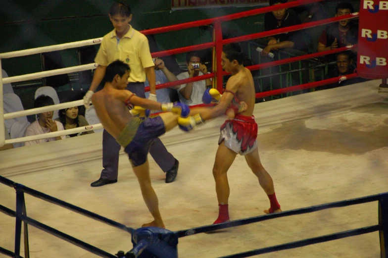 a group of men standing around a boxing ring