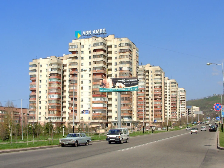 a long highway with cars driving on it and tall buildings