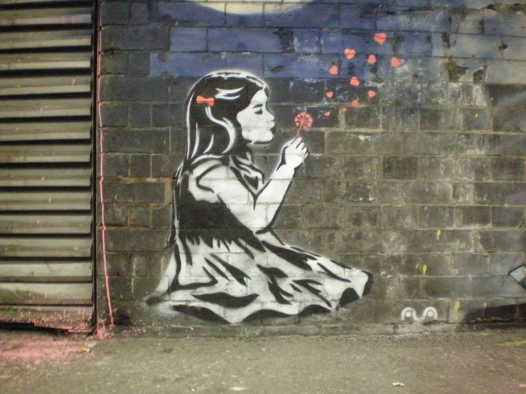 a woman in white and black sitting in front of a graffiti wall