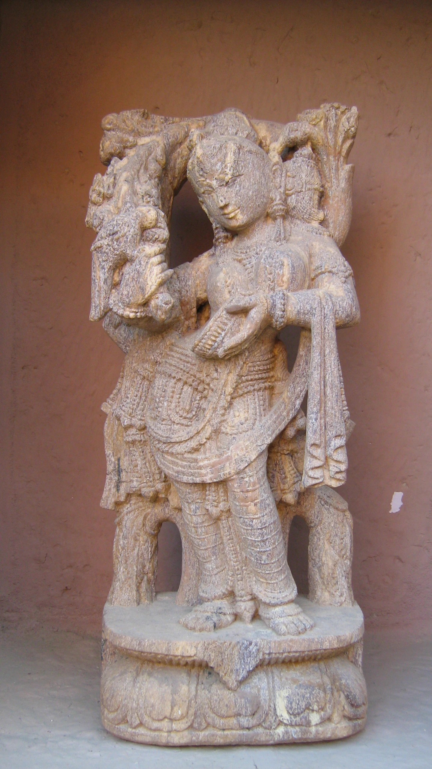 a decorative statue made of concrete depicting an elephant and man with a bird on his back