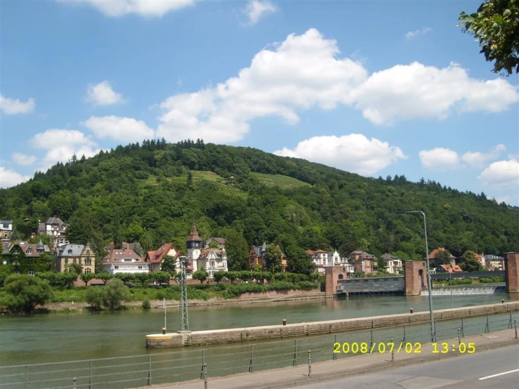 a river and a mountain landscape and some houses