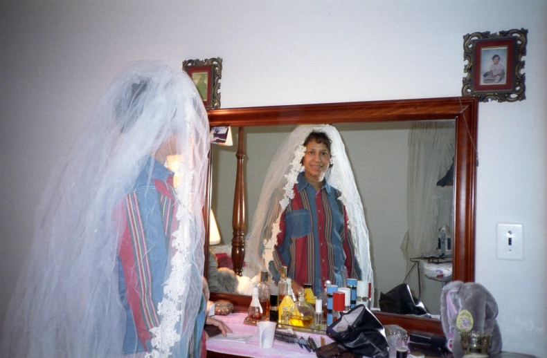 a woman stands in front of a mirror