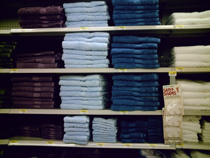 a store shelf has various folded and unwrapped towels on it