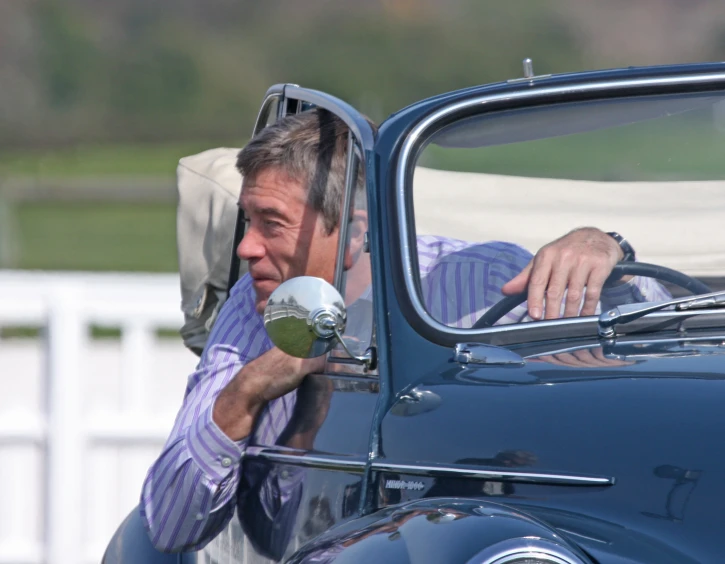 a man is sitting in the car talking on a cell phone