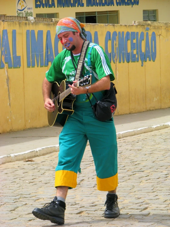 a man playing a guitar in front of a building