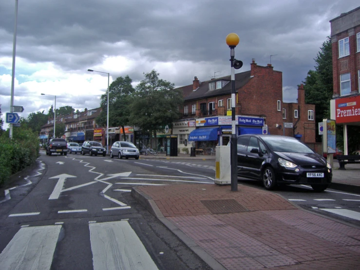 a car waiting at an intersection near some buildings