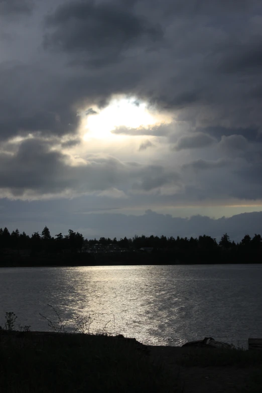 sun breaking through the clouds in the sky over water