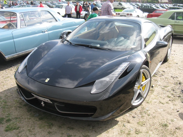 a large black sports car parked on dirt
