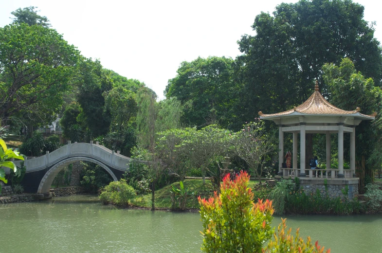 the gazebo and small bridge are among the trees