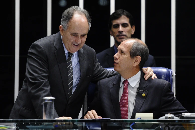 two men looking at another mans head in a conference room