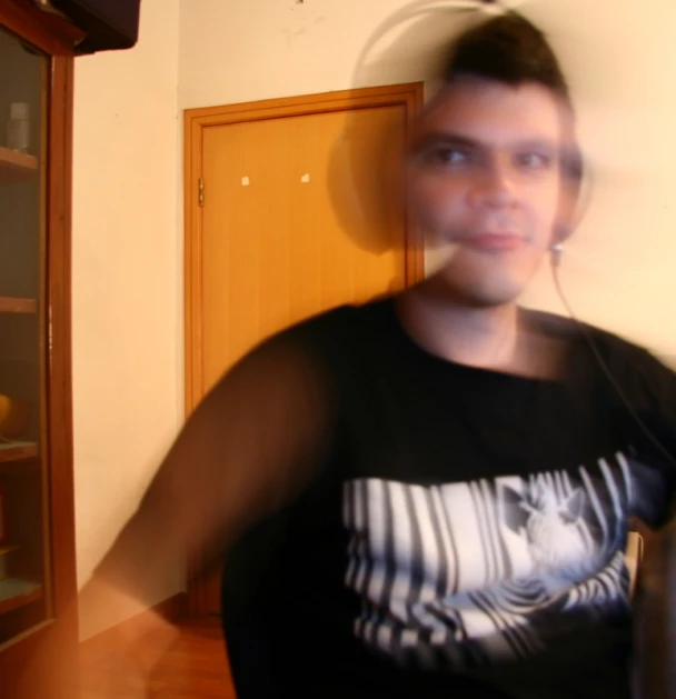 a blurry po of a boy in a t - shirt looking straight ahead