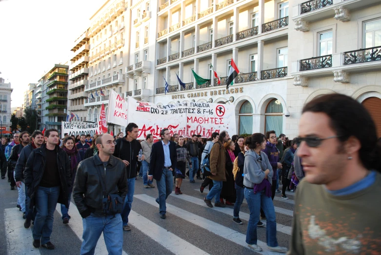 many people are walking on the street near buildings