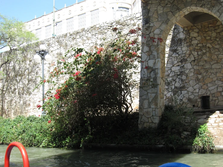 a building is made of stone and has flowers growing up the outside of it