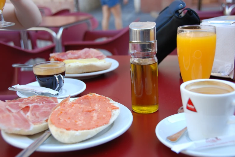 a red table with some white plates and food