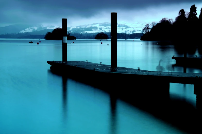 a dock on the lake with several boats floating in it