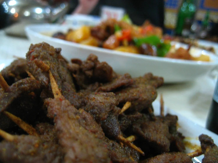 the plate of meat is sitting next to two bowls