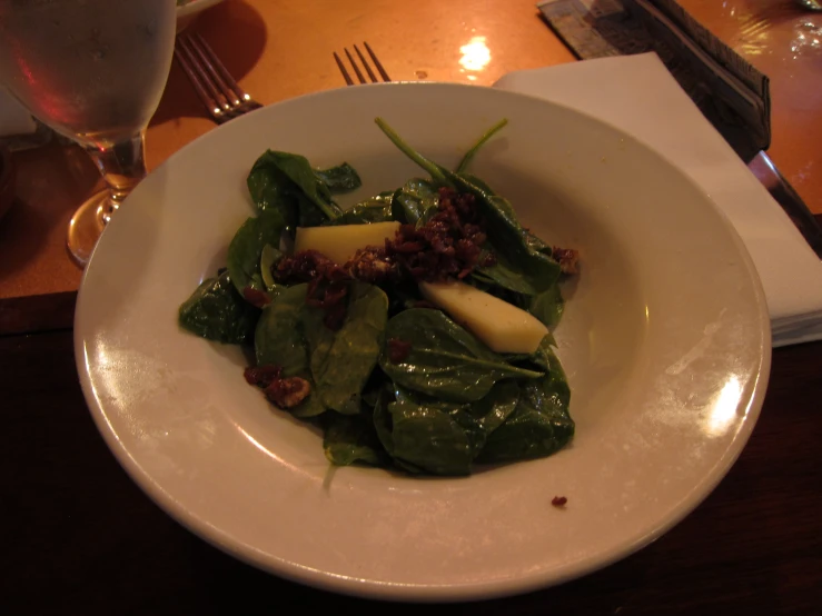 a small white plate has green leaves with apples