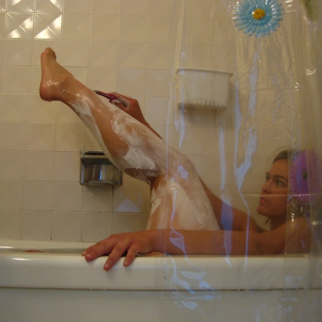 a woman is soaking in the tub in the shower
