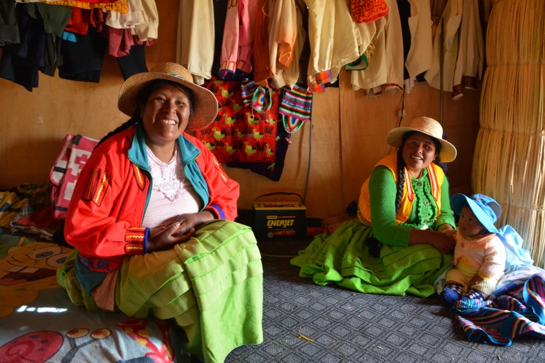 two women in colorful clothing, one with a basket and the other with a hat