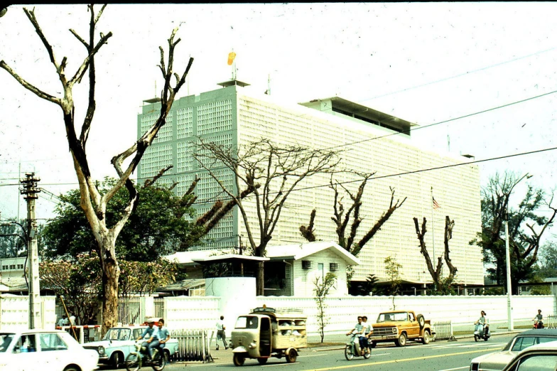 an old truck driving past tall buildings on the road