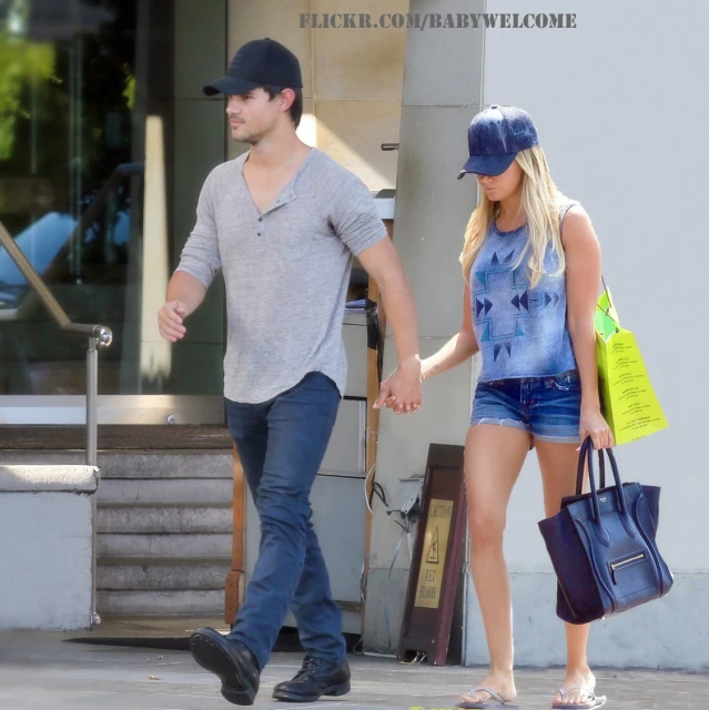 a man and woman walking together while carrying shopping bags