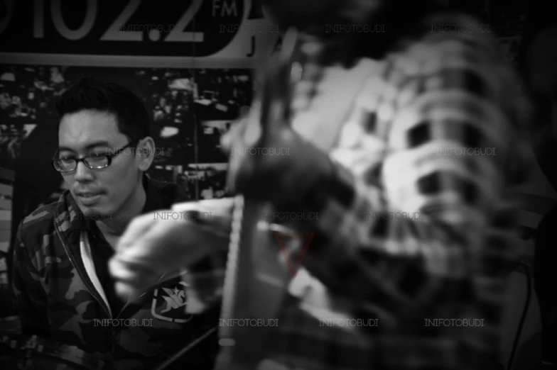 man in glasses sitting by a computer keyboard