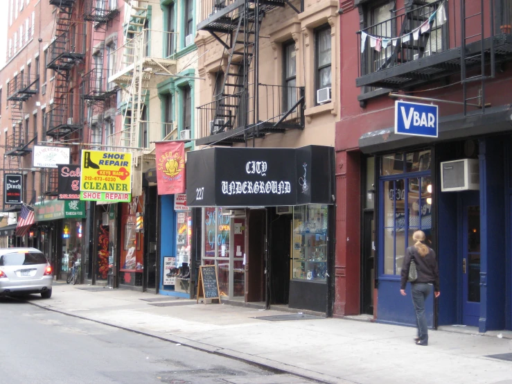 the sidewalk is lined with shops and signs