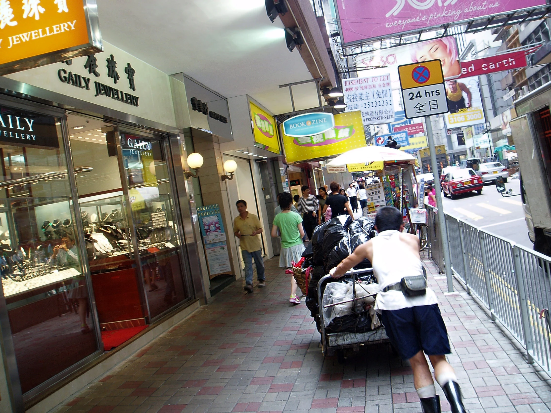 people stand outside a chinese jewelry store on a city street