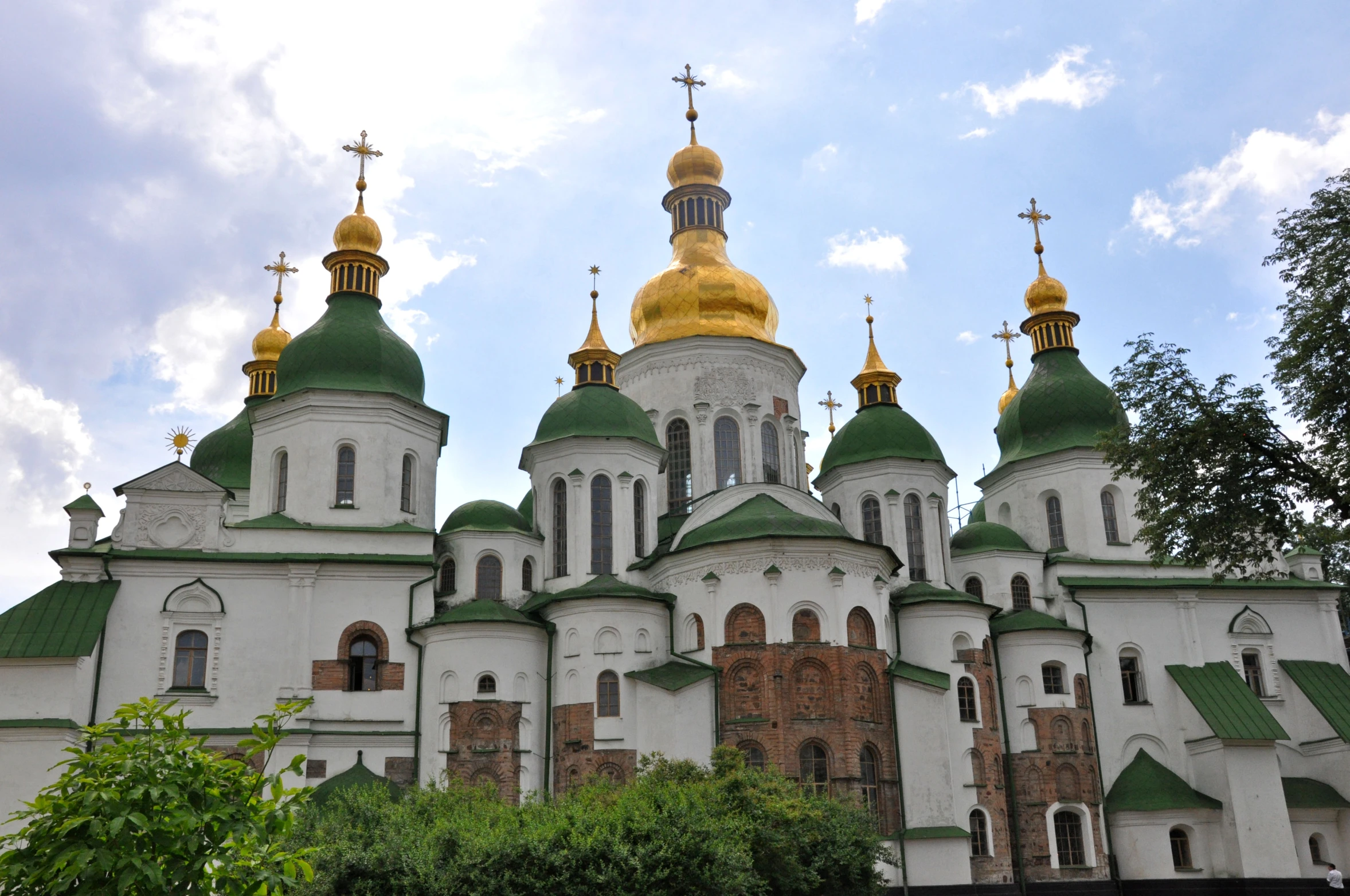 the domes of a large building are painted white and yellow