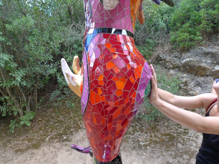 a lady has painted the face of a sculpture