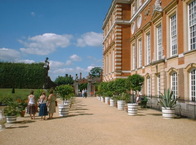 people walk down a sidewalk in a courtyard at a home