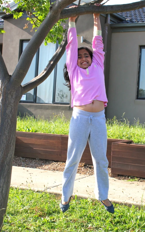 a woman is balancing on a tree limb