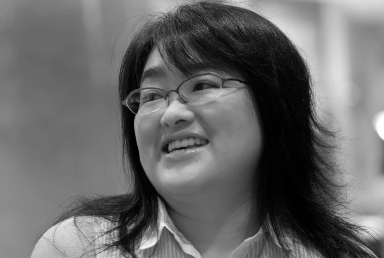 woman with large glasses smiling for the camera