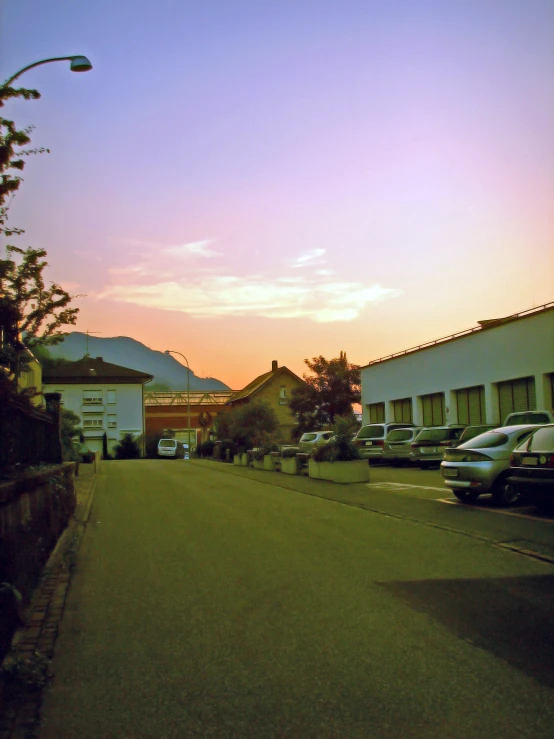 a street near some buildings is shown at sunset