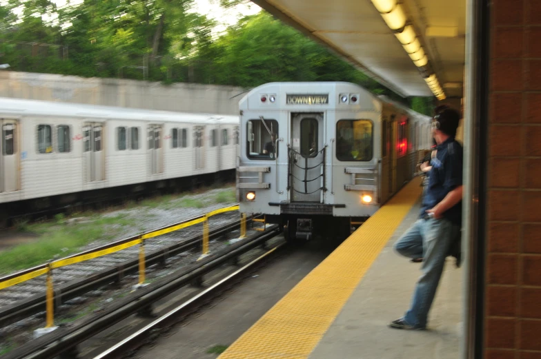 a man walking on the platform beside a passenger train