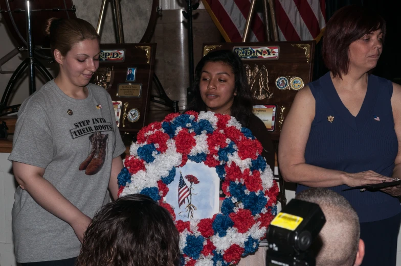 a woman is being handed a wreath at an event