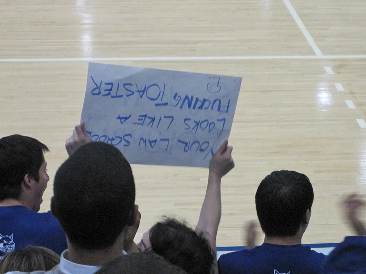 people are holding up signs on the court