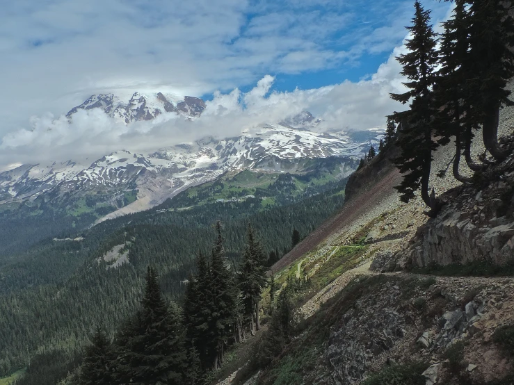 a view of mountains and clouds as they are from the top of a hill