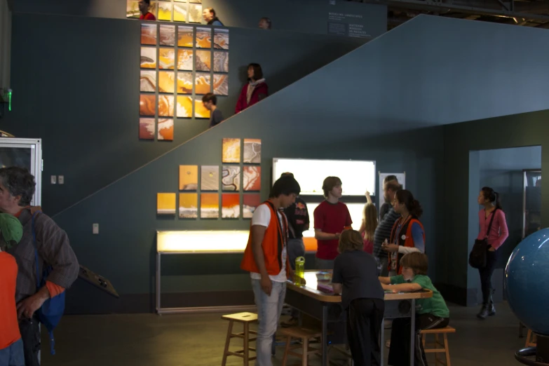 several people gather around a table in a museum