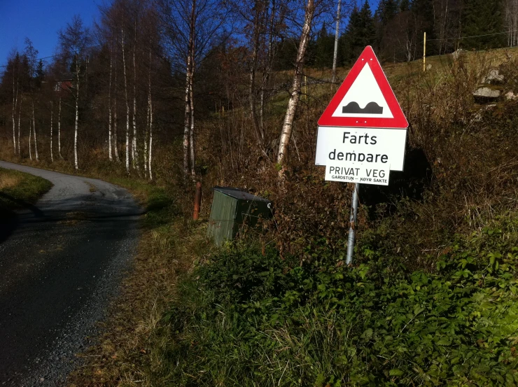 a road sign sits on a small hillside