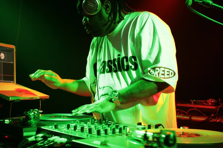 man standing in front of decks and mixing at the same time