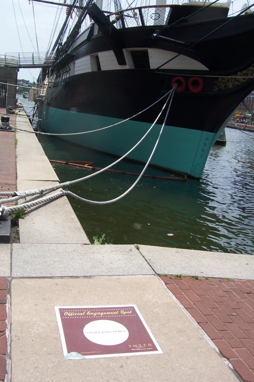 a boat that is tied up to the docks next to a plaque