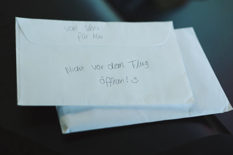 an envelope with writing on it sits open