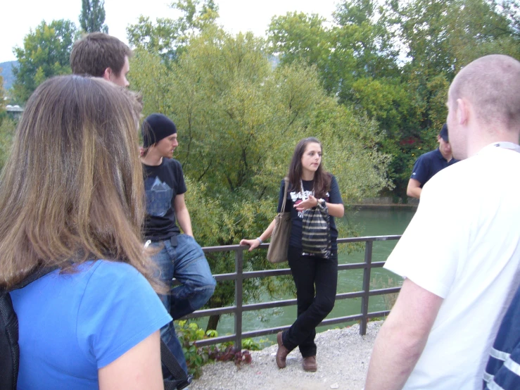 four young people are standing together, looking at soing on a trip