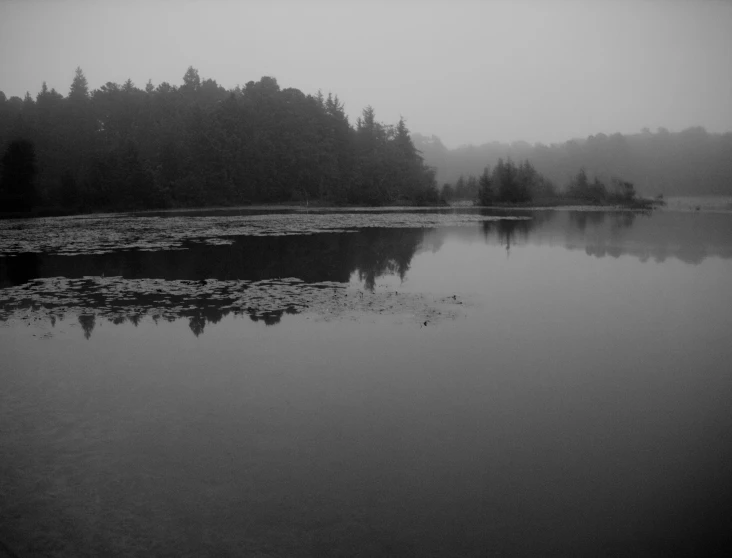 a lake with small ripples on it with fog
